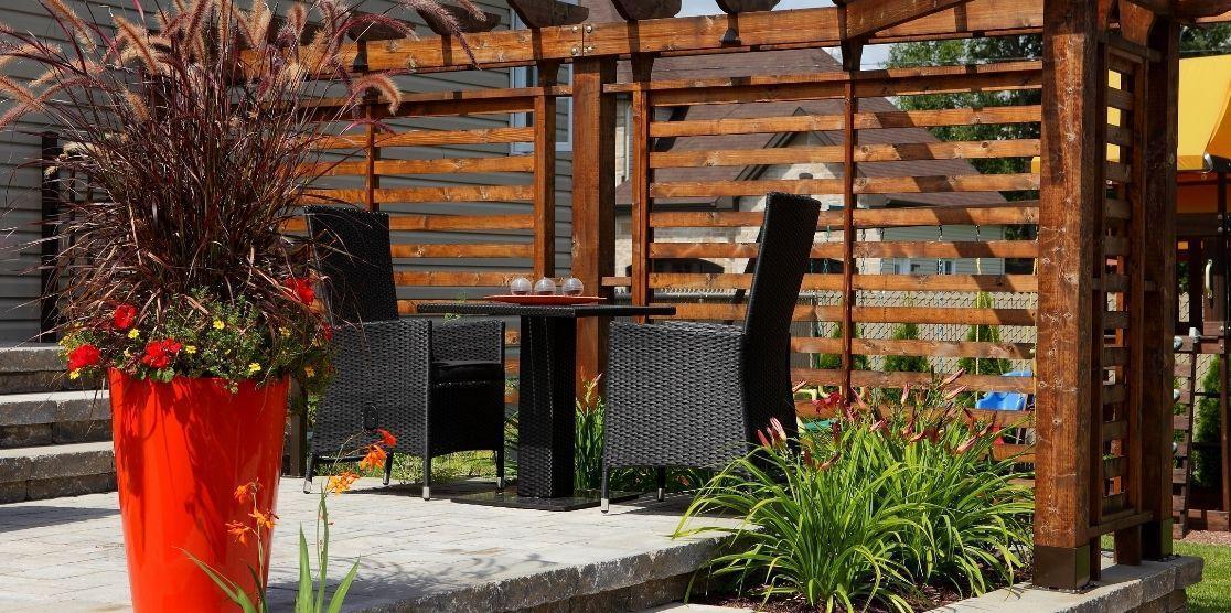 Pergola avec écran d'intimité à lattes de bois horizontales au-dessus d'un patio en pavé